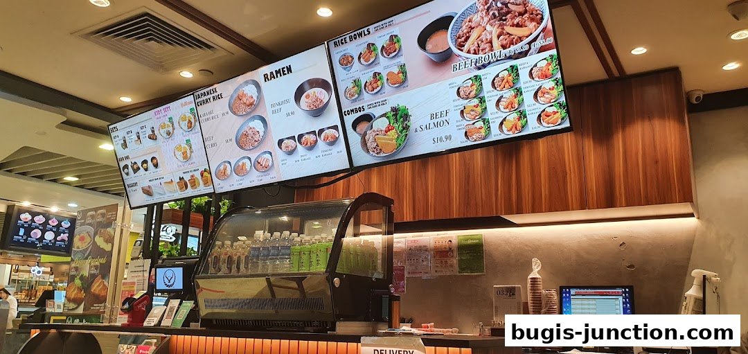 Digital menu boards displaying Japanese food items like ramen, curry rice, and beef bowls.