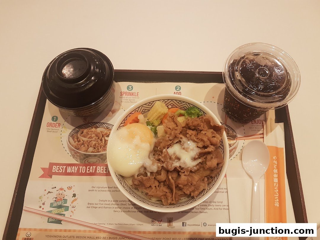 A Yoshinoya Beef Bowl meal with a drink and soup, presented on a tray with instructions.