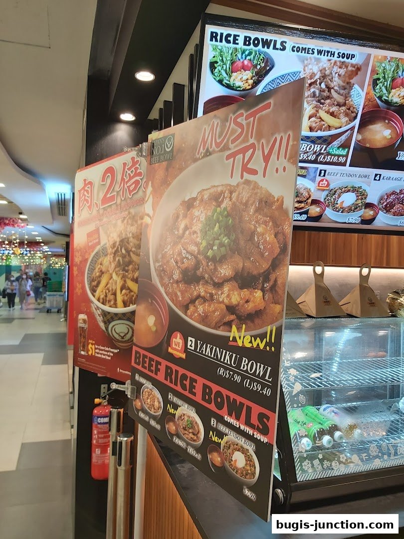 A display board showcasing Yoshinoya's popular beef rice bowls with enticing images and prices.