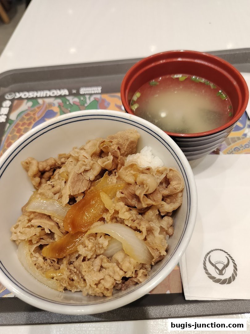 A bowl of Yoshinoya's signature beef bowl with a side of miso soup.